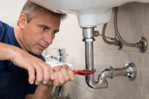 Closeup,Of,Male,Technician,Fixing,Sink,Pipe,In,A,Bathroom