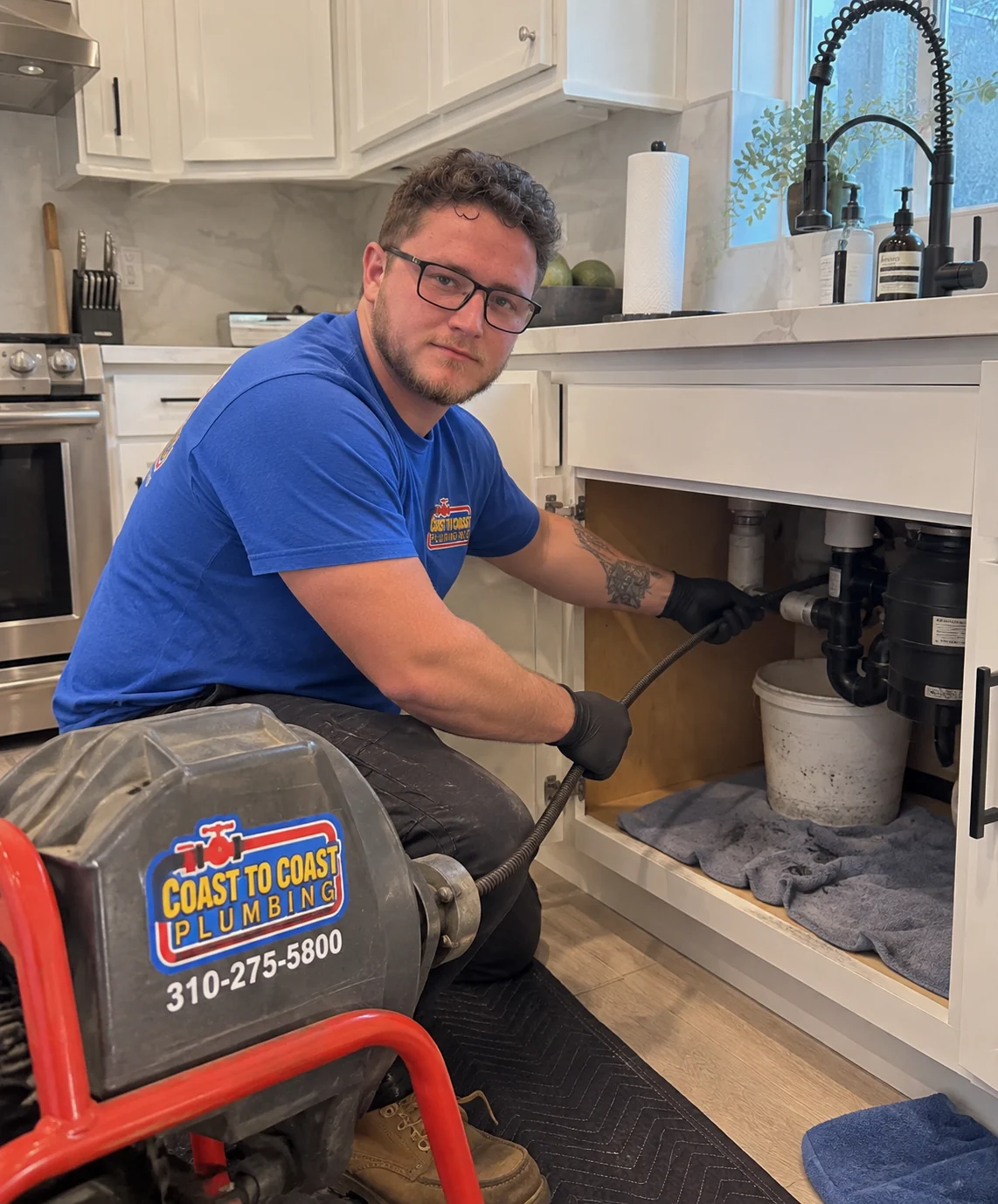 Technician clearing a kitchen sink drain